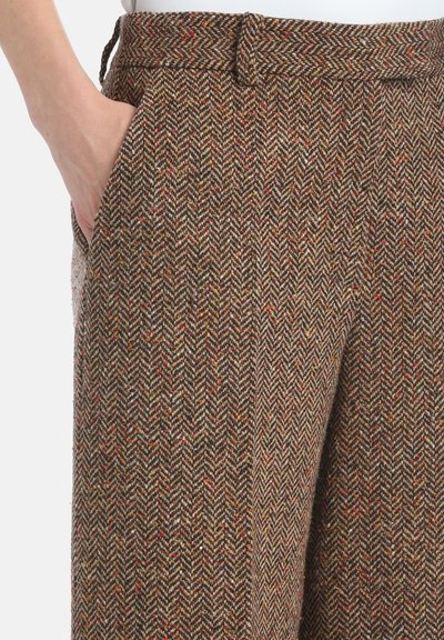 Biezi brūni bikses ar eņģeļu zīmogojumu un teksturētu audumu. Ar jostu un sānu kabatām, ar smalkiem daudzkrāsainiem punktiem.