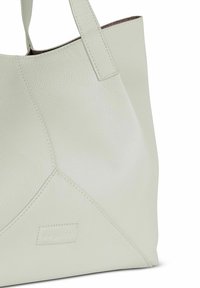 Borsa tote in pelle verde chiaro con superficie testurizzata e due manici. Presenta un design a pannello triangolare e un dettaglio del logo impresso.