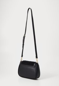 Borsa a spalla nera con corpo in pelle e parte superiore in tessuto nero testurizzato. Dotata di una lunga tracolla regolabile e dettagli in hardware dorato.