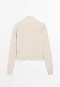 Maglione beige lavorato a maglia con colletto alto e maniche lunghe. Presenta una trama a coste e un'orlo dritto con una piccola cerniera sul retro.
