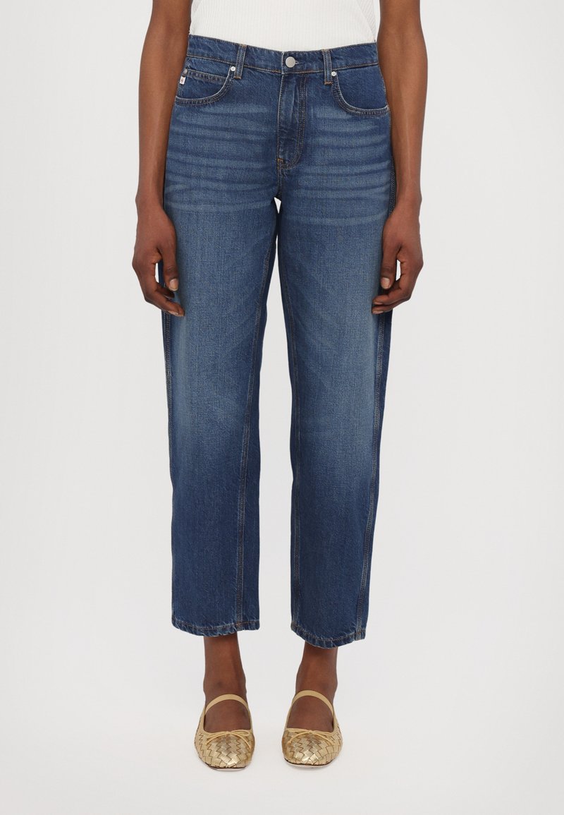 Vaqueros de denim en un lavado azul oscuro, diseño de pierna recta, con una cintura de media altura, cinco bolsillos y costuras en contraste. Material de algodón texturizado.