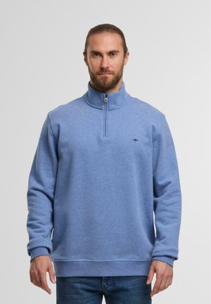 Hellblauer Fleece-Pullover mit halbem Reißverschlusskragen, gerippten Bündchen und Saum. Besitzt ein kleines Logo auf der Brust. Weiche Textur und lockere Passform.