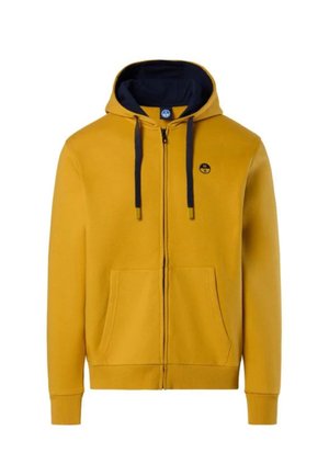 Felpa zip-up gialla senape con cappuccio, cordini neri, tasche frontali, polsini a coste e un piccolo logo circolare sul lato sinistro del petto.