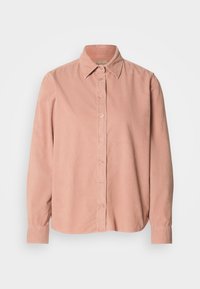 Chemise en velours côtelé à manches longues, boutonnée, rose poudré, avec col pointu et poignets, présentée à plat sur fond blanc.