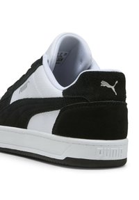 Zapatillas en blanco y negro con parte superior de ante y material sintético, punta redonda, cuello acolchado y suela de goma texturizada. Presenta un logo de Puma.