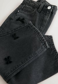 Jeans in denim nero con dettagli in velluto a forma di fiocco, con vita classica, design a cinque tasche e tessuto testurizzato.