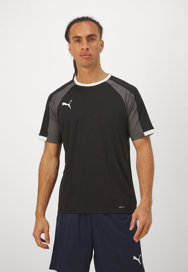 Sort atletisk t-shirt med grå paneldetaljer og hvid trim. Logo vist på venstre bryst. Korte ærmer, glat tekstur.