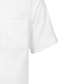 Camicia bianca a maniche corte realizzata in tessuto morbido, con taschino sul lato sinistro del petto, orlo rotondo e dettaglio del logo ricamato vicino alla spalla.