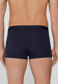 Námořnické modré boxerky s texturovaným pasem s logem "TEZENIS". Hladká tkanina, přiléhavý střih, vykrojené nad stehnem.
