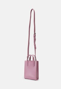 Bolsa de couro rosa com um design estruturado, alças duplas curtas e uma alça longa ajustável. Textura suave sem padrões visíveis.