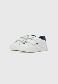 Hvite sneakers med blå detaljer, laget av glatt syntetisk materiale, med borrelåsremmer og en logo på remmen og hælen.