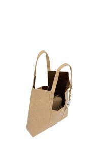 Beige vegansk læder tote bag med to forlængede skulderremme, en udvendig lomme og dekorativ fletning med perler.