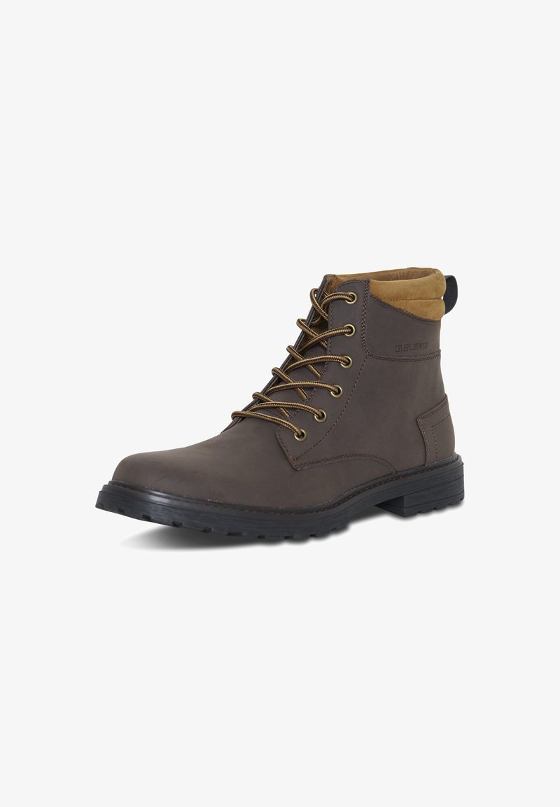 Bottines en cuir marron avec un col beige, dotées d'œillets en métal, de lacets, d'une semelle en caoutchouc texturée et d'une languette au talon.