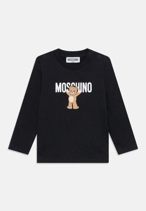 T-shirt bébé noir à manches longues avec texte blanc MOSCHINO et un dessin d’ours en peluche souriant au centre sous le col.