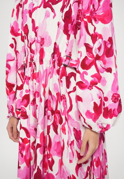 Rochie cu imprimeu floral, prezentând nuanțe de roz pe un fond alb, cu talie strânsă și mâneci vaporoase. Accentuata cu un detaliu de cataramă.