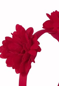 Czerwona opaska na głowę ozdobiona dwoma dużymi, teksturowanymi dekoracjami w kształcie kwiatów na jednolitym białym tle.