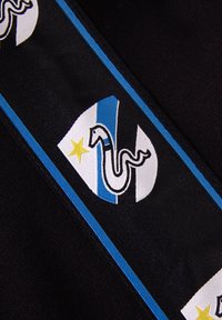 Zwarte stof met blauwe en witte strepen, voorzien van een embleem van een slang en een ster. Het ontwerp is geborduurd met gedetailleerde contouren.