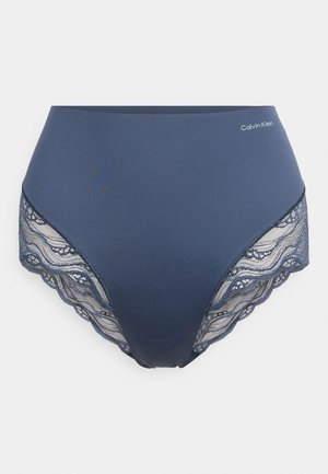 Slip blu navy a vita alta con rifiniture in pizzo, caratterizzati da bordi ondulati e una cintura liscia. Logo Calvin Klein sul davanti.