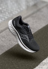 Black running shoe with a breathable mesh upper, textured design, and reflective accents. Features a white midsole and rubber outsole.