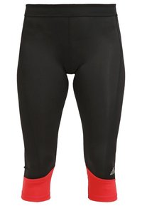 Sorte atletiske tights med røde manchetter, trekvart længde, med Adidas-logoet på venstre benmanchet.