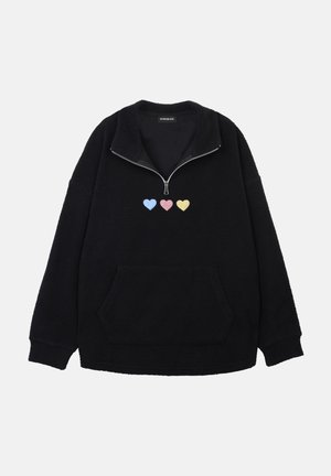 Μαύρο φλις πουλόβερ με ψηλό γιακά και μισό φερμουάρ. Διαθέτει μπροστινή τσέπη και τρεις κεντημένες καρδιές σε παστέλ αποχρώσεις στο στήθος.