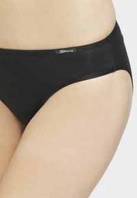 Sorte bikini-underbukser lavet af glat, strækbart stof, med medium taljehøjde og et lille logo på taljebåndet.