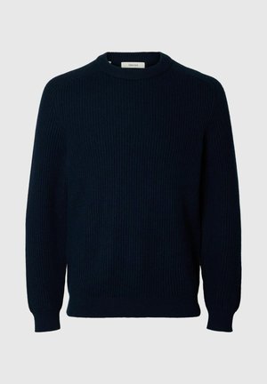 Tumši jūras zilas krāsas adīta džemperis ar ribotu tekstūru, apaļu kakla izgriezumu un garām piedurknēm. Iezīmē vienkāršu, vienkrāsainu dizainu bez papildu rakstiem.