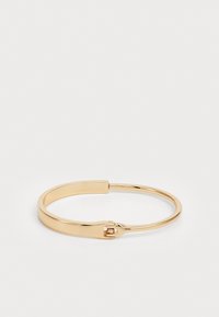 Gullmetall bangle armbånd med et glatt, avrundet design. Har en sikker lås med en liten detalj. Polert finish uten mønstre.
