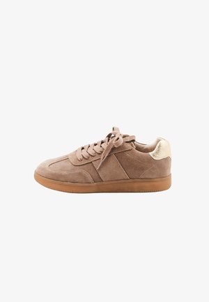 Brown suede sneaker with flat laces, almond toe shape, rubber gum sole, and a textured cream accent on the heel.