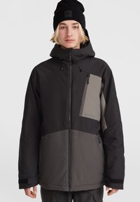 Chaqueta de invierno negra y gris con capucha, que cuenta con un bolsillo en el pecho con cremallera, puños ajustables y una tela suave y texturizada.