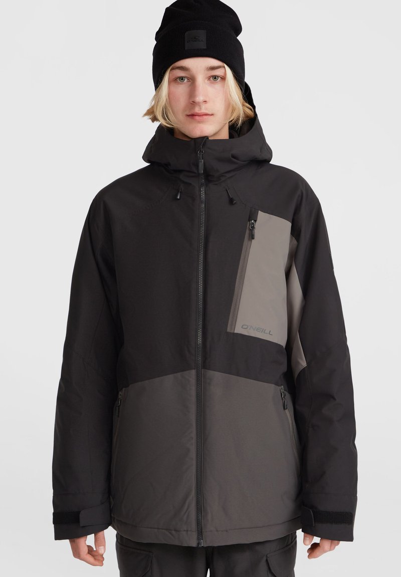 Chaqueta de invierno negra y gris con capucha, que cuenta con un bolsillo en el pecho con cremallera, puños ajustables y una tela suave y texturizada.