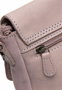 Borsa in pelle viola chiaro con una tasca con zip, cuciture a contrasto e una texture liscia. Presenta un cappuccio arrotolato e un tirazip metallico.
