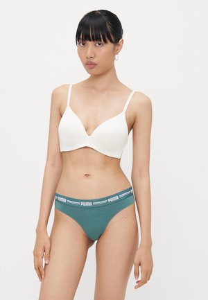 Witte gevoerde beha met verstelbare banden, gecombineerd met turkooise panties met een witte logoband. Glad materiaal en aansluitend ontwerp.