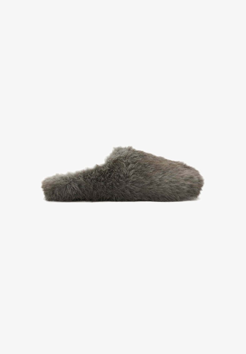 Chausson gris doux et pelucheux à enfiler, avec un bout fermé et un talon ouvert, conçu pour une utilisation intérieure et le confort.