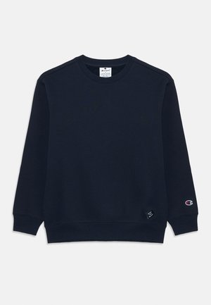 Sweatshirt ras du cou bleu marine en coton doux. Présente des poignets et un ourlet côtelés, une petite étiquette en bas à gauche et un logo sur la manche droite.