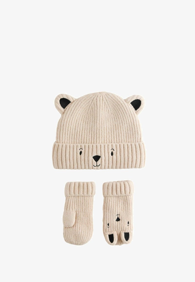 Gorro beige de punto con orejas y cara de oso, combinado con manoplas a juego con el mismo diseño de cara de oso.