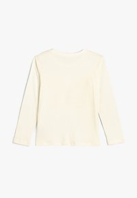 Camicia a maniche lunghe in cotone bianco sporco. Collo rotondo semplice, orlo dritto e texture liscia. Nessun motivo visibile o decorazioni.