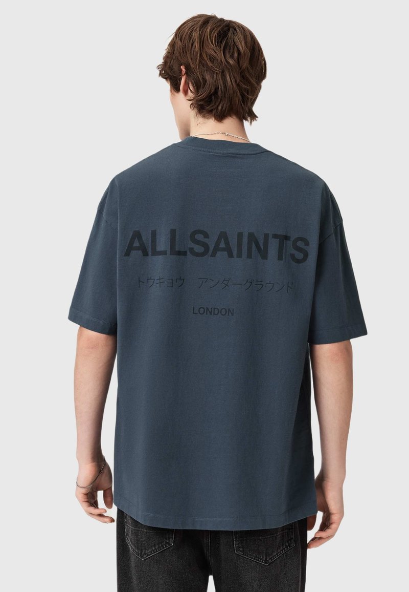 Dark blue cotton t-shirt with short sleeves. Black printed text on back: "ALLSAINTS," Japanese characters, and "LONDON" underneath.