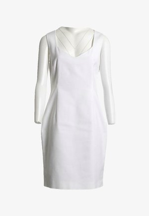 Robe blanche sans manches jusqu'aux genoux avec un profond décolleté en V, présentée sur un buste de mannequin blanc sur un fond uni.