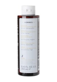 Transparante cilindrische fles shampoo, amberkleurig, met een witte dop, meertalige label en tekst die rijstproteïnen en linde benadrukt.