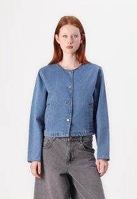 Σακάκι τζιν σε ανοιχτό μπλε χρώμα με στρογγυλή λαιμόκοψη, μακριά μανίκια, κλείσιμο με κουμπιά μπροστά και πλάγιες τσέπες. Διαθέτει κομμένη σχεδίαση.