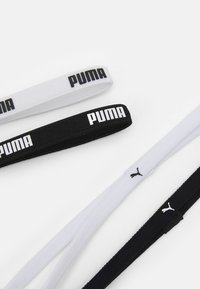 Elastické čelenky PUMA v černé a bílé barvě mají hladký povrch a kontrastní logo. Každá čelenka má přibližnou šířku 1,5 cm.