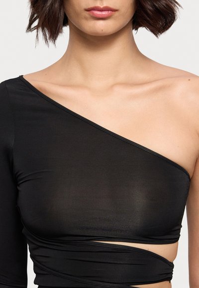 Black one-shoulder top made of stretchy fabric with a fitted design and ruched detailing around the midsection. Smooth texture.