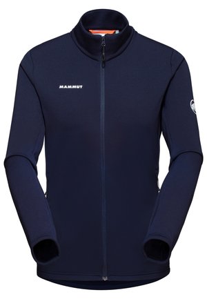 Marineblå fleecejakke med høj krave, fuldlængde lynlås og tommelhuller. Har Mammut-logo på brystet og ærmet. Glat tekstur.