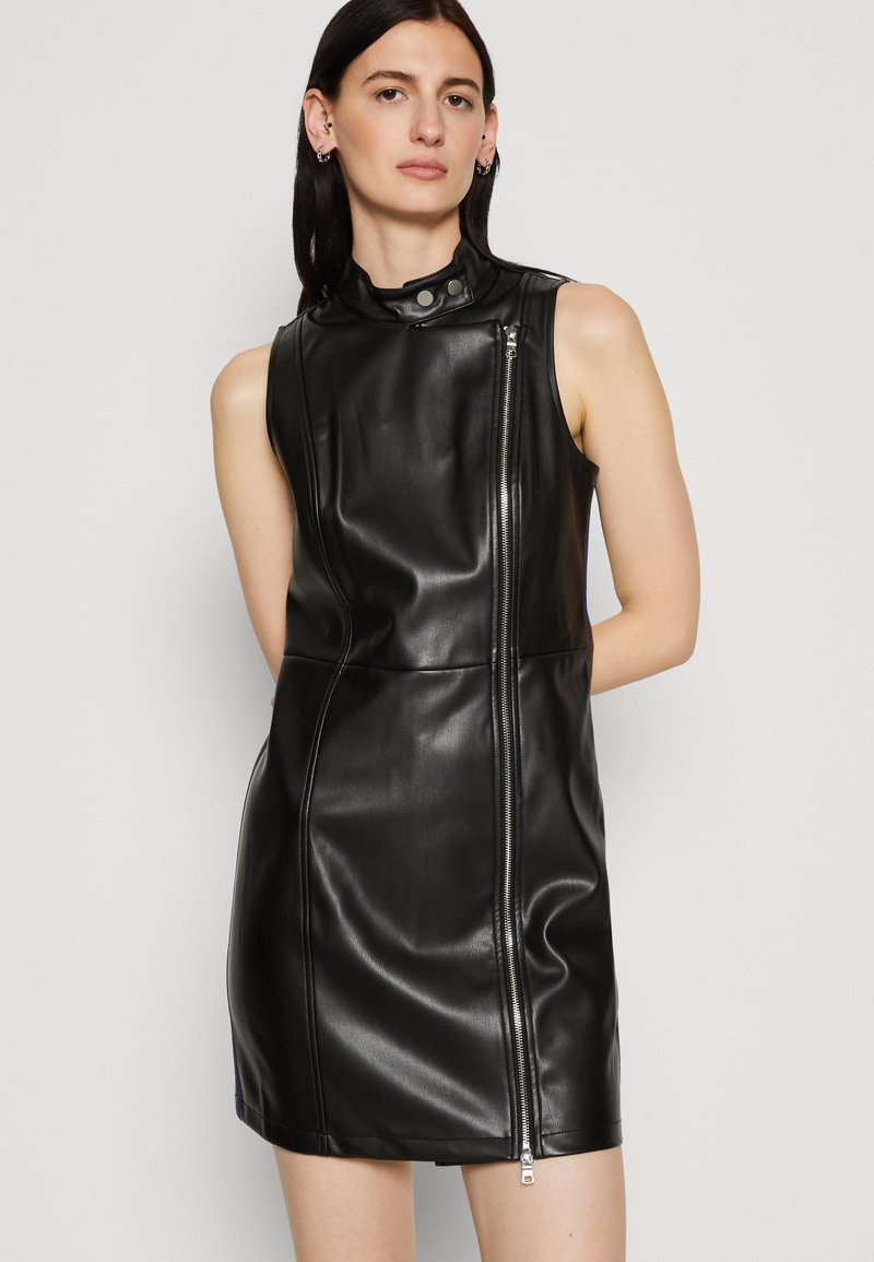 Abito senza maniche in pelle nera con colletto alto, caratterizzato da una cerniera laterale e un design aderente. Texture liscia e silhouette elegante.