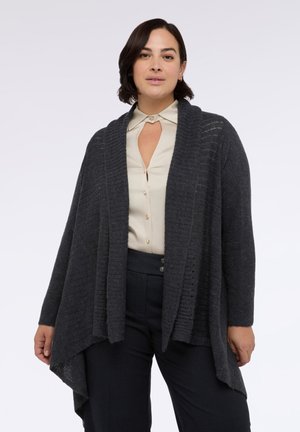 Cárdigan de punto gris oscuro con un diseño abierto y textura acanalada. Presenta un diseño drapeado y aberturas laterales para mayor comodidad de movimiento.