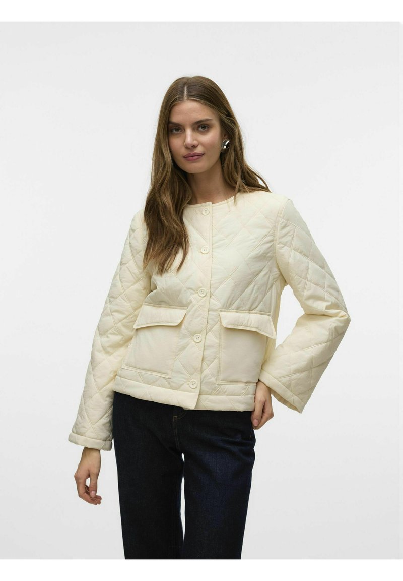 Chaqueta acolchada en crema con cuello redondo, botones delanteros y dos grandes bolsillos. Presenta mangas anchas y una silueta estructurada.