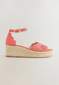 Sandalo con zeppa rosa corallo con ricami floreali traforati, cinturino alla caviglia con fibbia dorata e suola piattaforma in corda intrecciata.