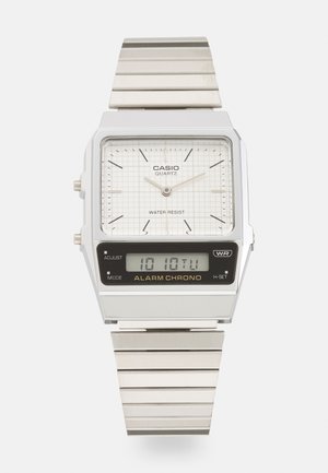 Strieborné kvarcové hodinky Casio s obdĺžnikovým ciferníkom, texturovaným bielym dialom, analógovými ručičkami, digitálnym displejom a kovovým náramkom. Vodoodolné.