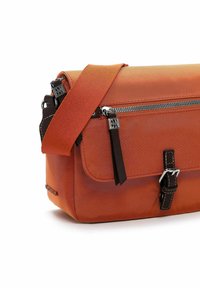 Orange nylon bag with a zip closure, featuring brown leather accents, adjustable strap, and a front flap with a buckle detail.